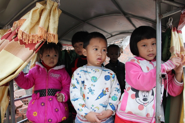 Chiếc xe được đóng khung sắt bao quanh, lắp mái tôn và rèm che mưa nắng để đảm bảo sức khỏe và sự an toàn cho các cháu.