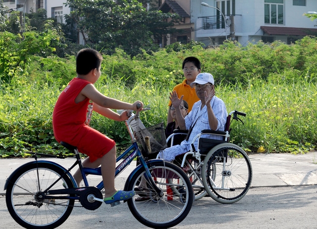 Dù là người lớn hay trẻ nhỏ đi qua, ông đều vẫy tay chào hỏi.