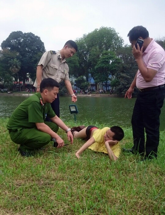  Tưởng mình là nàng tiên cá, nam thanh niên tạo dáng, “phơi mình” bên Tháp Rùa. 