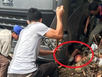 Hơn 10 người giải cứu nạn nhân kẹt dưới gầm xe tải trên quốc lộ 2, đoạn qua thị xã Phú Thọ trưa 12/5. Ảnh: Đoàn Tân.