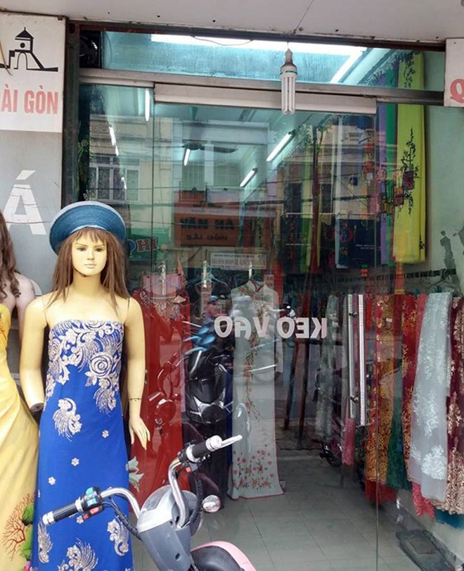 Dan vay co gai di xe SH nghi moc tui trong shop thoi trang hinh anh 1