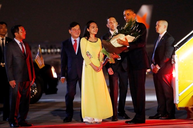 Mỹ Linh mặc áo dài vàng có họa tiết hoa sen thêu tay, tặng hoa Tổng thống Mỹ Barack Obama /// Ảnh: Reuters