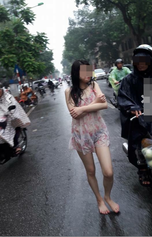 Hành động quá khó hiểu của cô gái giữa phố Hà Nội ngày mưa - Ảnh 2.