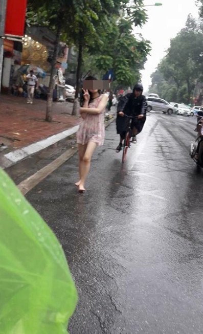 Hành động quá khó hiểu của cô gái giữa phố Hà Nội ngày mưa - Ảnh 3.