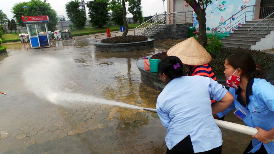 Khu vực sân tòa nhà HH2E, các nhân viên tòa nhà dùng vòi cứu hỏa để đuổi bùn dày đặc sau khi bị ngập.