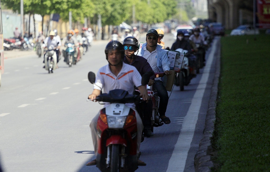  Hàng người đi xe máy nép vào phần đường có bóng râm để tránh nắng trên trục đường Khuất Duy Tiến - Nguyễn Xiển. Hai ngày nay Hà Nội nắng gắt, nhiệt độ ngoài trời có lúc lên đến hơn 40 độ C. 
