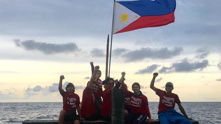  Một nhóm các nhà hoạt động chụp ảnh cùng quốc kỳ Philippines tại bãi cạn Scarborough (Ảnh: AFP) 