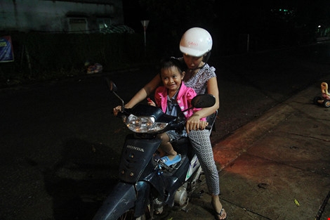 Bé Lan Anh được mẹ nuôi Thu Trang chở đi chợ trong lần về thăm nhà cũ. Ảnh: HOÀNG GIANG