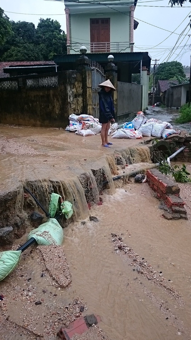 Nước mưa cùng bùn đất tràn xuống khu dân cư. Rút kinh nghiệm lần trước, lần này người dân đã chủ động xếp các bao cát để chặn bùn đất cao như chiến lũy nên thiệt hại đã giảm đi rất nhiều.