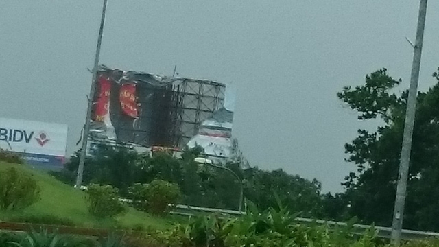  Biển quảng cáo bị gió đánh tơi tả. 