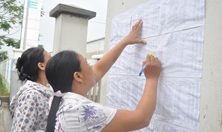 Công nhân ghi thông tin sổ BHXH trước cổng Cty TNHH Gmie (Bắc Ninh). Ảnh: T.T. 