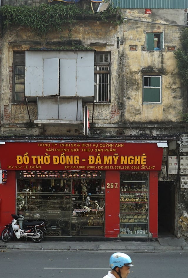 Một ngôi nhà trên phố Lê Duẩn, bên dưới rực rỡ màu đỏ, còn bên trên thâm trầm, cũ kỹ. 