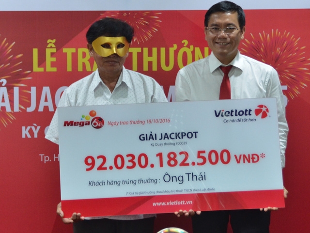 Ông Thái (phải) đeo mặt nạ lúc nhận thưởng để tránh những rắc rối sau một đêm trở thành tỉ phú?