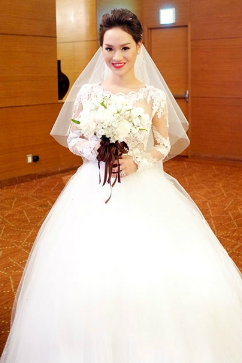 [Caption] Chiếc váy thứ hai Trà My diện trong nghi thức làm lễ chính của lễ cưới do nhà thiết kế Hoàng Hải thực hiện. Váy may từ chất liệu ren nhập từ Italy và đá pha lê nhập từ Pháp. Kiểu dáng váy sang trọng, quyến rũ. Bộ váy này có giá ước tính khoảng 3.000 USD.