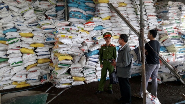 Lực lượng chức năng đang kiểm tra trong nhà kho của DTTN Yên Tâm, chứa hàng trăm tấn phân bón không nhãn mác