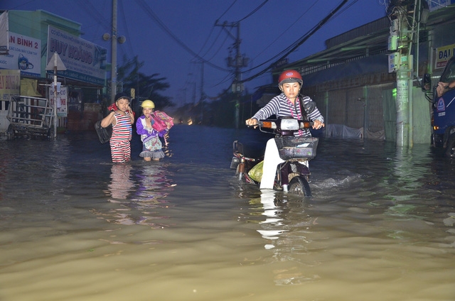  Mẹ đẩy xe, con vác cặp cùng bơi đến trường. 