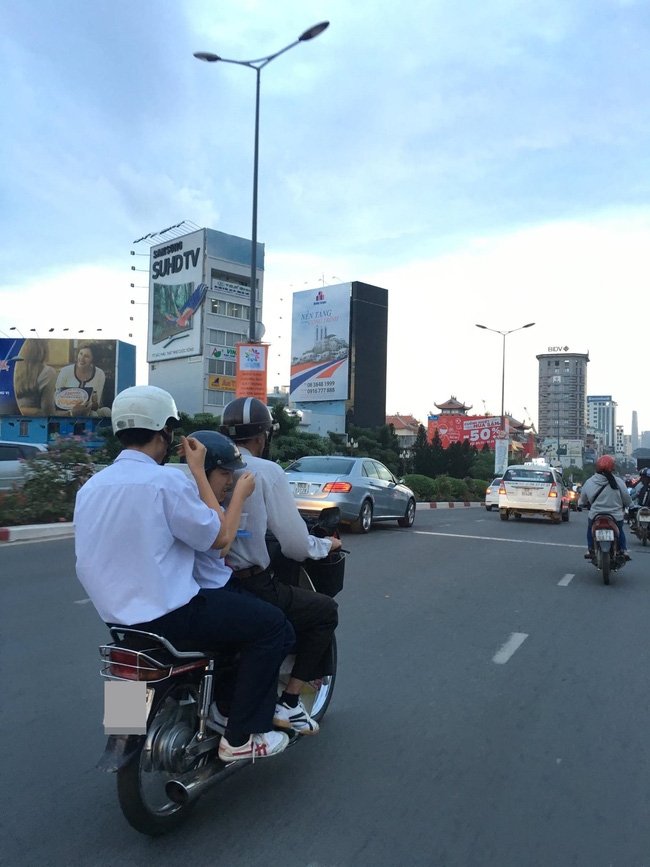 Clip: Học sinh vừa đi đường vừa tranh thủ xúc cơm ăn ngay trên xe máy - Ảnh 3.