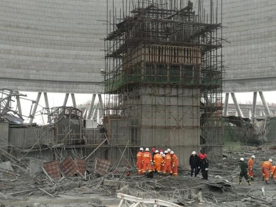 Nhân viên cứu hộ đang tìm kiếm một công nhân mất tích. Ảnh: REUTERS