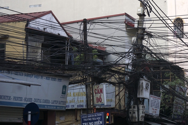 Chiếc cột điện xiêu vẹo chống đỡ búi dây chằng chịt.