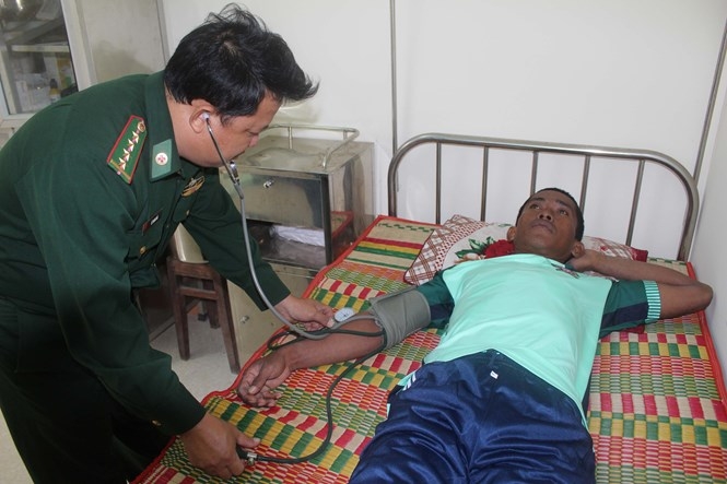 Bộ đội biên phòng Quảng Ngãi chăm sóc sức khỏe cho ngư dân Edwin /// Ảnh: HIỂN CỪ