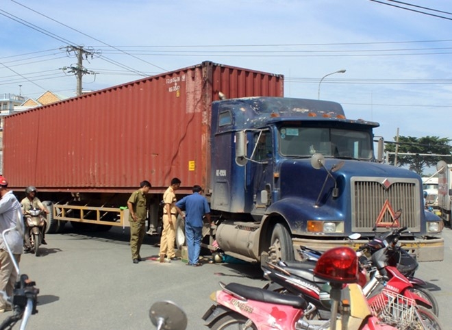 Phu nu di xe may bi xe dau keo container cuon vao gam hinh anh 1