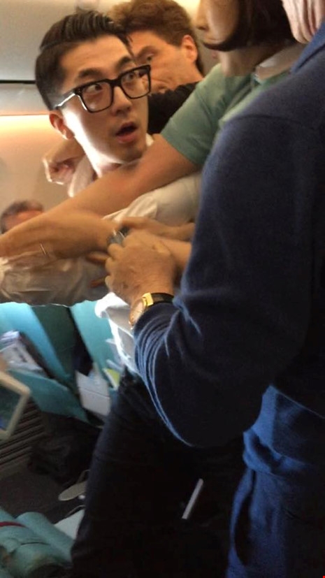 Hành khách (mang kính) quậy trên máy bay Korean Air bị ca sĩ Marx và các hành khách khác khống chế. Ảnh: TWITTER