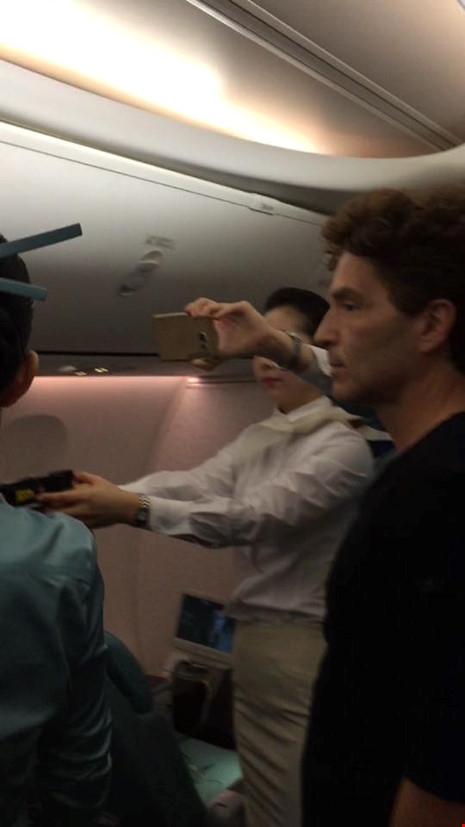Thành viên phi hành đoàn Korean Air cầm súng điện trong vụ khống chế hành khách quậy. Ảnh: TWITTER