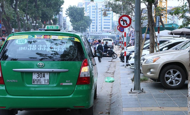 Cảnh xe ô tô, taxi dừng đỗ trái phép trên phố Giảng Võ hướng đi phố Láng Hạ trong giờ nghỉ trưa. Dọc tuyến phố Giảng Võ có nhiều quán ăn, cà phê, toà nhà công sở nên tình trạng các phương tiện dừng đỗ trái phép thường xuyên diễn ra. 