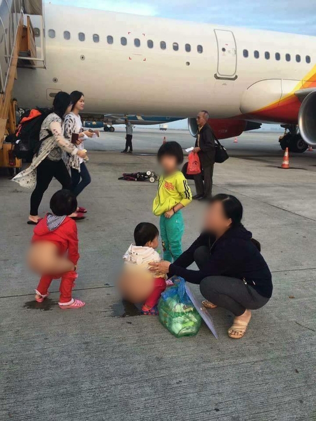 Người mẹ hồn nhiên cho 2 bé gái đi vệ sinh ngay giữa đường băng máy bay - Ảnh 1.