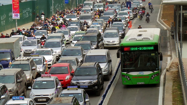 Đường phố Hà Nội những ngày giáp Tết, giờ nào cũng là giờ cao điểm. Trên phố Giảng Võ, xe buýt nhanh một mình một đường, trong khi hàng nghìn phương tiện khác nối dài, ken cứng phần đường còn lại.