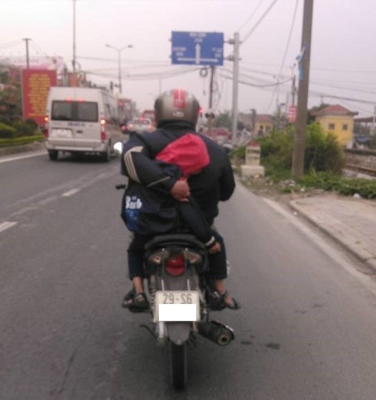 Nguoi cha vua lai xe may vua om con ngu tren duong quoc lo hinh anh 1