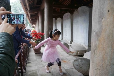 Cha mẹ khuyến khích con cái vượt rào sờ đầu rùa lấy may, mặc bảo vệ nhắc nhở tới nơi tới chốn. Ảnh: Nguyên Khánh