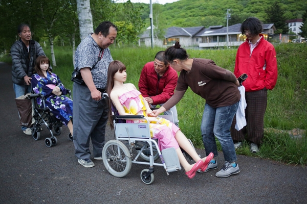 Senji shows Saori to local residents after a photo session with his friend at a lake in Nagan