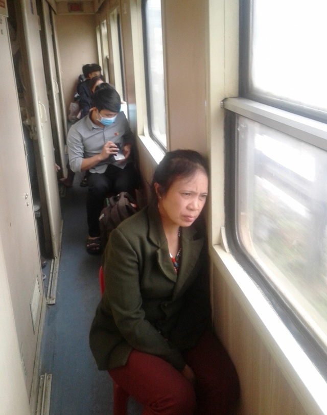 Hành khách mệt nhoài ngồi hành lang trên chuyến tàu Bắc - Nam