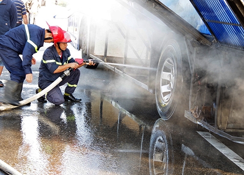 Lính cứu hoả phun nước, dập ngọn lửa. Ảnh: Quảng Lâm