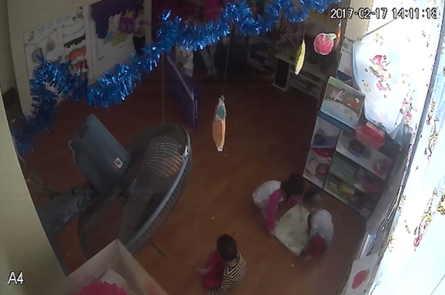 Cháu tè dầm nhưng không báo cô. (Bé trai ngoài cùng bên phải, mặc quần đỏ áo xanh nhạt (lên camera là màu xám)