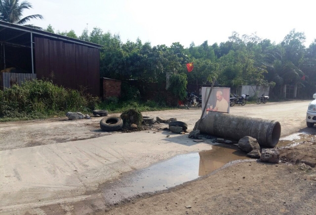  Người dân dùng rào chắn để chặn đường không cho xe tải ra vào mỏ đá. 