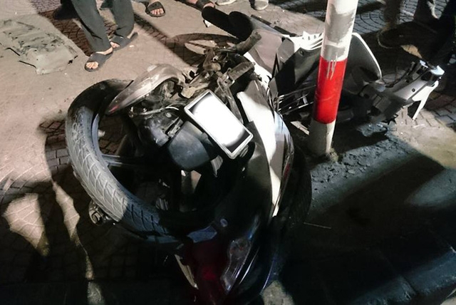 Xe máy hư hỏng nặng sau khi lao vào cột biển báo trên vỉa hè.