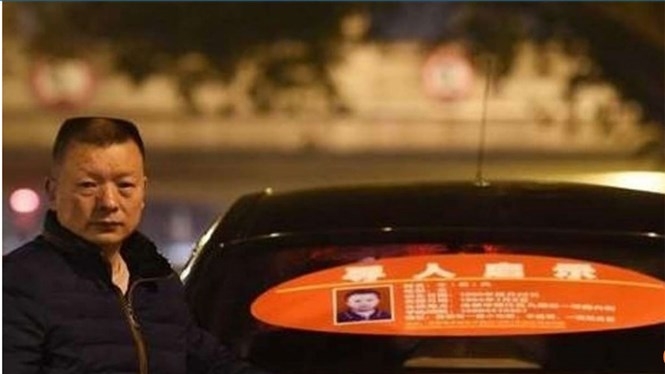 Ông Wang Mingqing bên cạnh chiếc taxi có dán bảng thông báo tìm đứa con gái mất tích /// Ảnh chụp trang web scmp