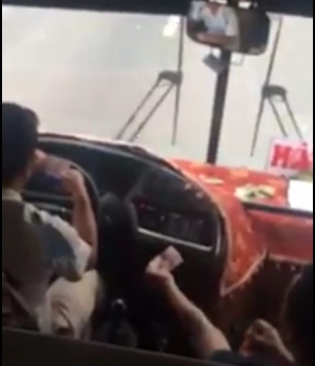  Tài xế và phụ xe soi số serie ăn tiền khi đang lái xe. (Ảnh cắt từ video clip) 