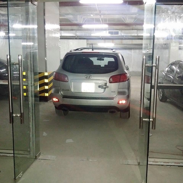 Một người dân đỗ xe dưới chân lối ra vào thang máy ở hầm gửi xe tòa nhà