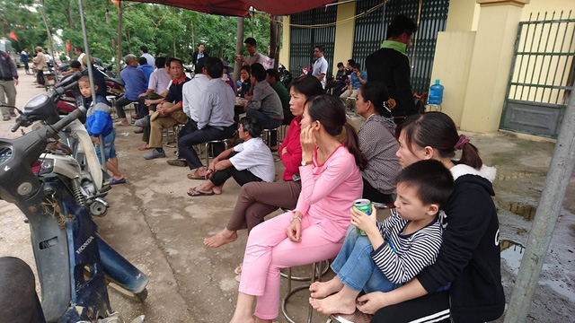  Người dân tập trung ở đầu làng lắng nghe nội dung buổi đối thoại qua loa truyền thanh. 