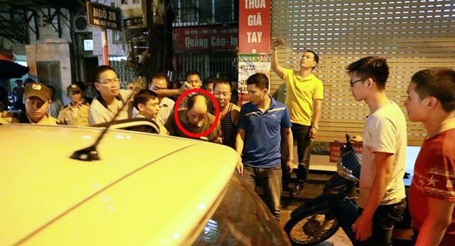 Sau 6 tiếng đồng hồ cố thủ trong nhà với con dao và chiếc xô đựng xăng, Hùng (khoanh tròn đỏ) đã chịu theo cảnh sát về trụ sở.