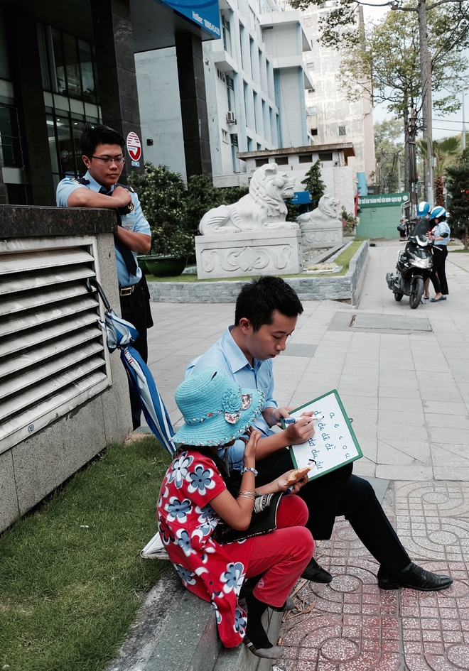 Anh nhân viên ngân hàng dành giờ nghỉ trưa mỗi ngày để dạy chữ cho cô bé vé số ngay trên vỉa hè Sài Gòn - Ảnh 1.