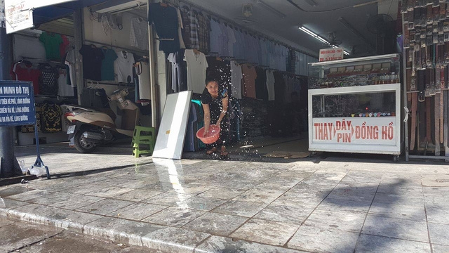Trên phố Hàng Ngang, các chủ cửa hàng phải liên tục tạt nước để giảm nhiệt