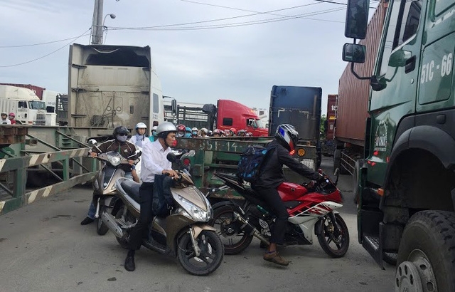  Xe máy luồn lách nguy hiểm giữa dòng xe tải, xe container... để tìm lối thoát. 