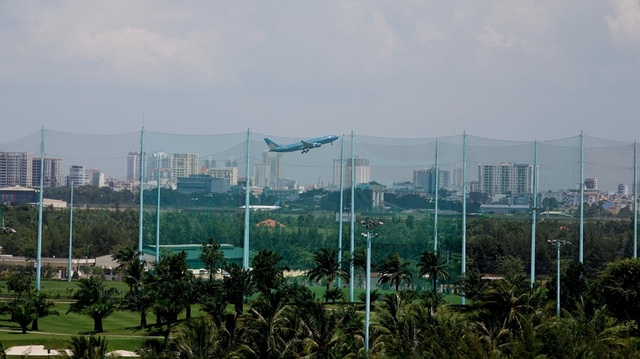  Qua lớp rào lưới chắn bóng, có thể nhìn thấy máy bay đang cất cánh. 