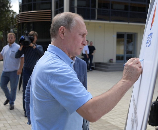 Ông Putin ký tên trên một tấm bảng đặt tại Trại Artek nhân chuyến thăm tới Crimea.