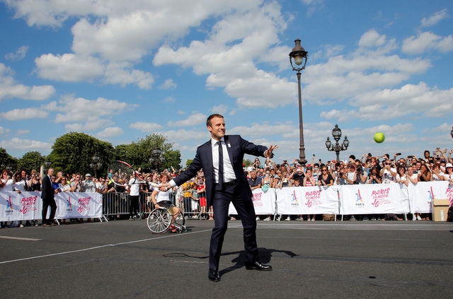 Tổng thống Macron mặc vest, cầm vợt thi đấu cùng các vận động viên quần vợt (Ảnh: Reuters)