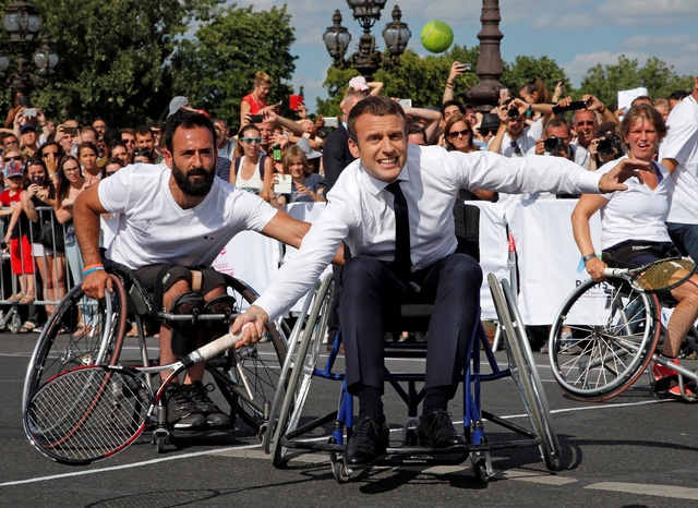 Ông Macron cởi áo vest, ngồi trên xe lăn chơi quần vợt với các vận động viên khuyết tật (Ảnh: Reuters)